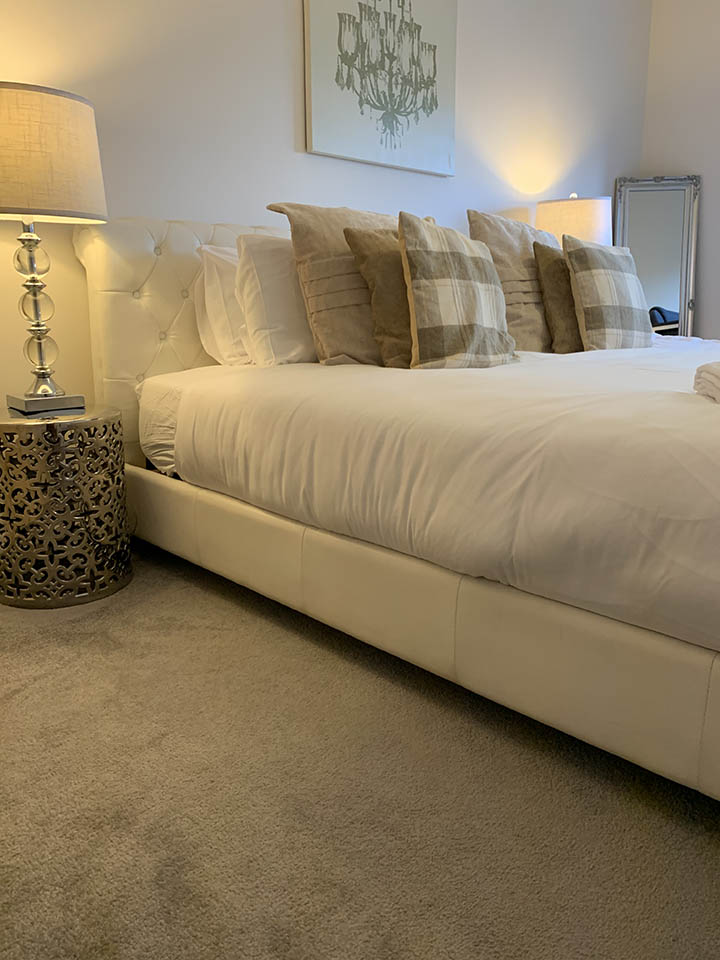 elegant bedroom setup wiph numerous pillows